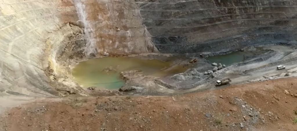 Eine Kobaltmine im Kongo. Wie ein Steinbruch abgegraben, ein riesiges Loch mit verschmutztem Wasser.