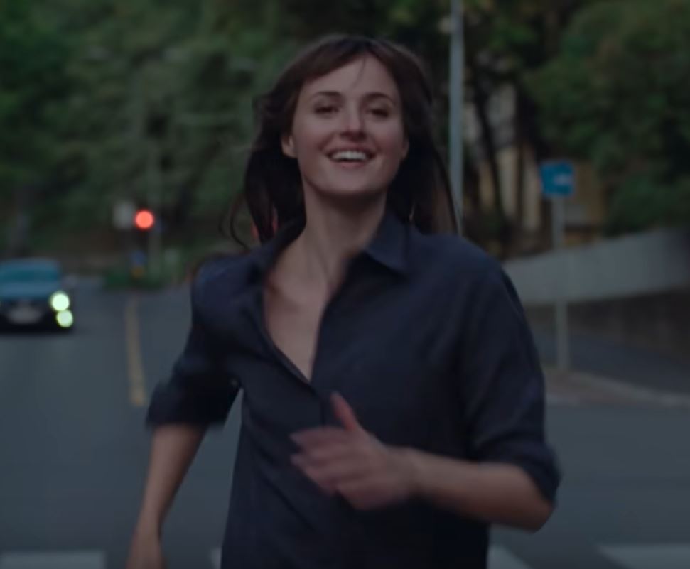Szeene aus dem Film "Der schlimmste Mensch der Welt". Die Protagonistin läuft lächelnd über eine Straße in Oslo