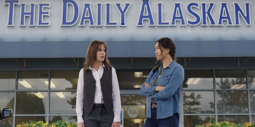 Szene aus "Alaska Dailey". Hilary Swank und Grace Dove stehen vor dem Gebäude der Zeitung "The Daily Alaskan".