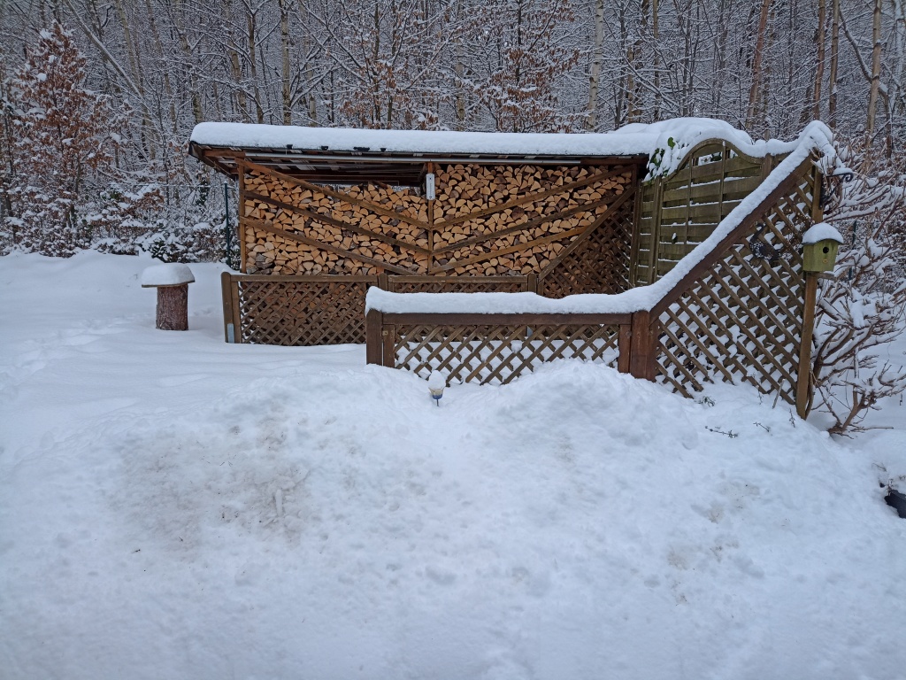 Unser Brennholzverschlag, davor die Holzterasse mit Geländer, als tief unter Schnee begraben.
